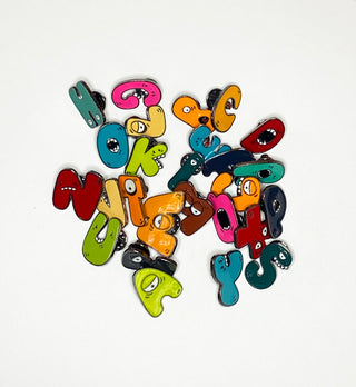 monogram enamel pins in assortment of colors