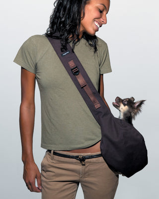 black messenger pouch carrier on human model with small model dog inside the carrier